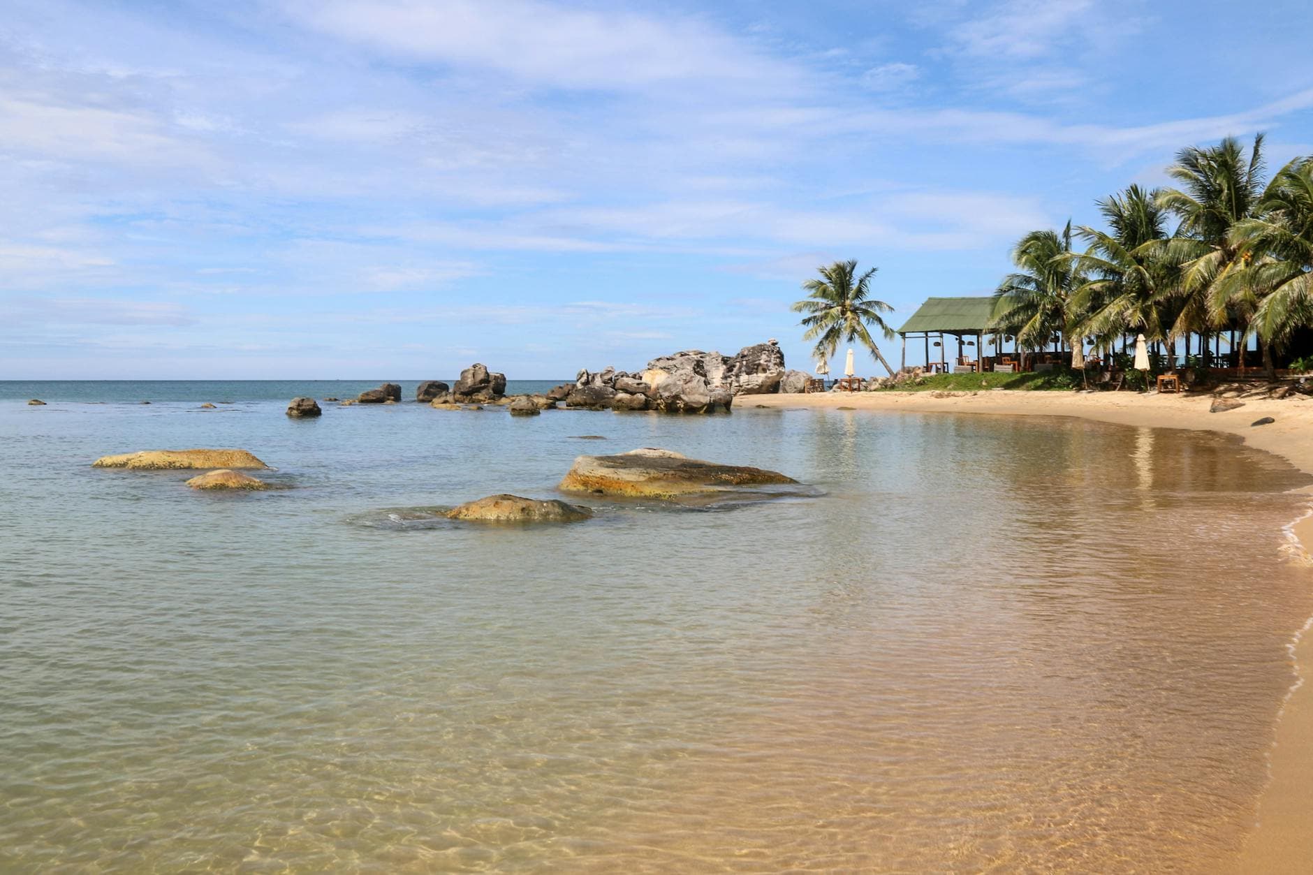 Clear water and palm-lined shore at one of the eight Cù Lao Chàm islands — administered as Xã Tân Hiệp, the only Hội An locality to keep its commune status through the 2025 reorganisation.