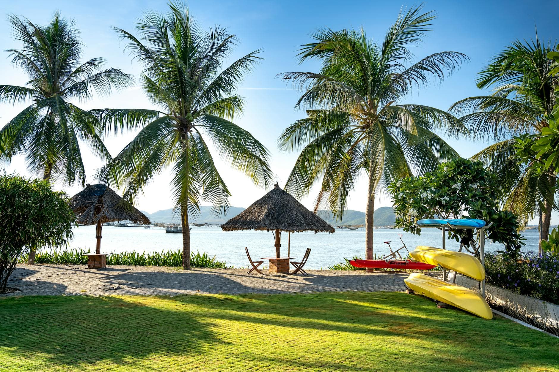 Quiet palm-shaded white-sand beach on the central Vietnam coast — the kind of unmarked stretch local cycling guides ride to from An Bàng beach near Hội An.