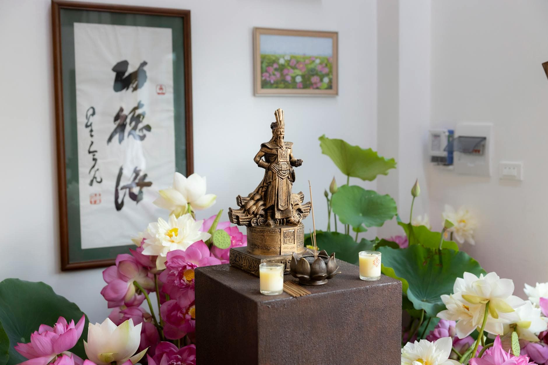 Pink lotus blossoms and curling incense smoke at a Vietnamese Buddhist altar — the offering pair (hoa sen + nhang) that visitors most often bring during Phật Đản week.