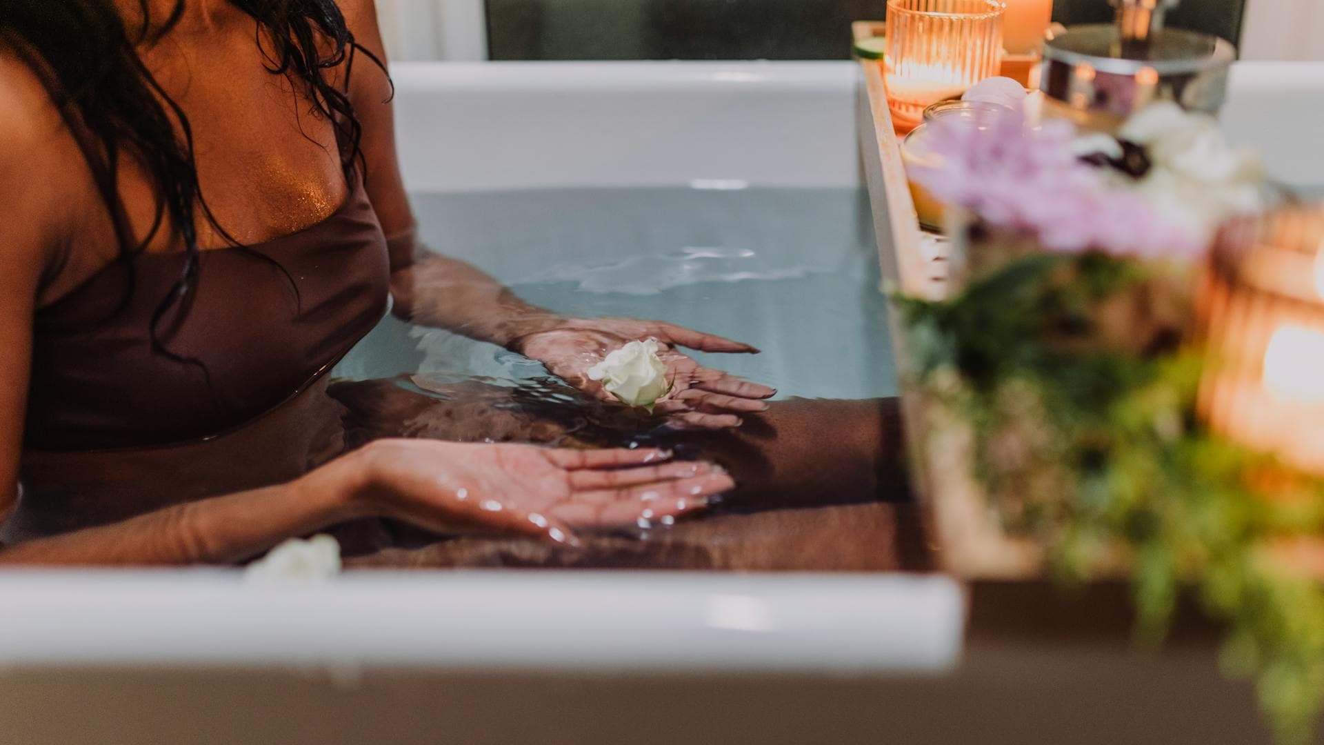 Serene spa bath with aromatic candles and fresh flowers promoting deep relaxation and recovery, inspired by traditional Vietnamese herbal bathing