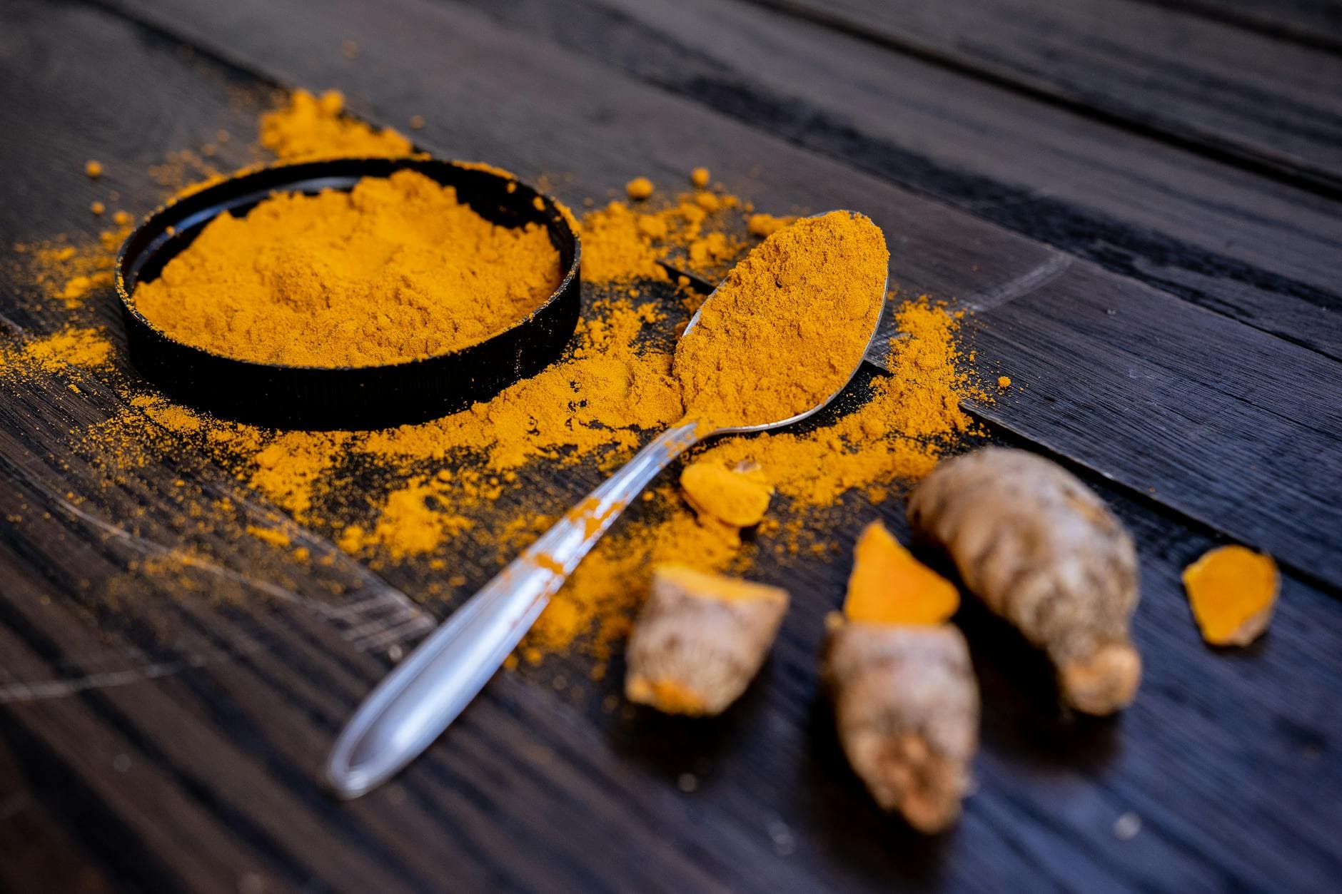 Fresh whole turmeric roots (nghệ vàng — Curcuma longa) on a market table — the single most pharmacologically studied herb shared between Vietnamese thuốc nam and South Indian Ayurveda, with α-glucosidase inhibition documented in Tạp chí Y học Việt Nam.