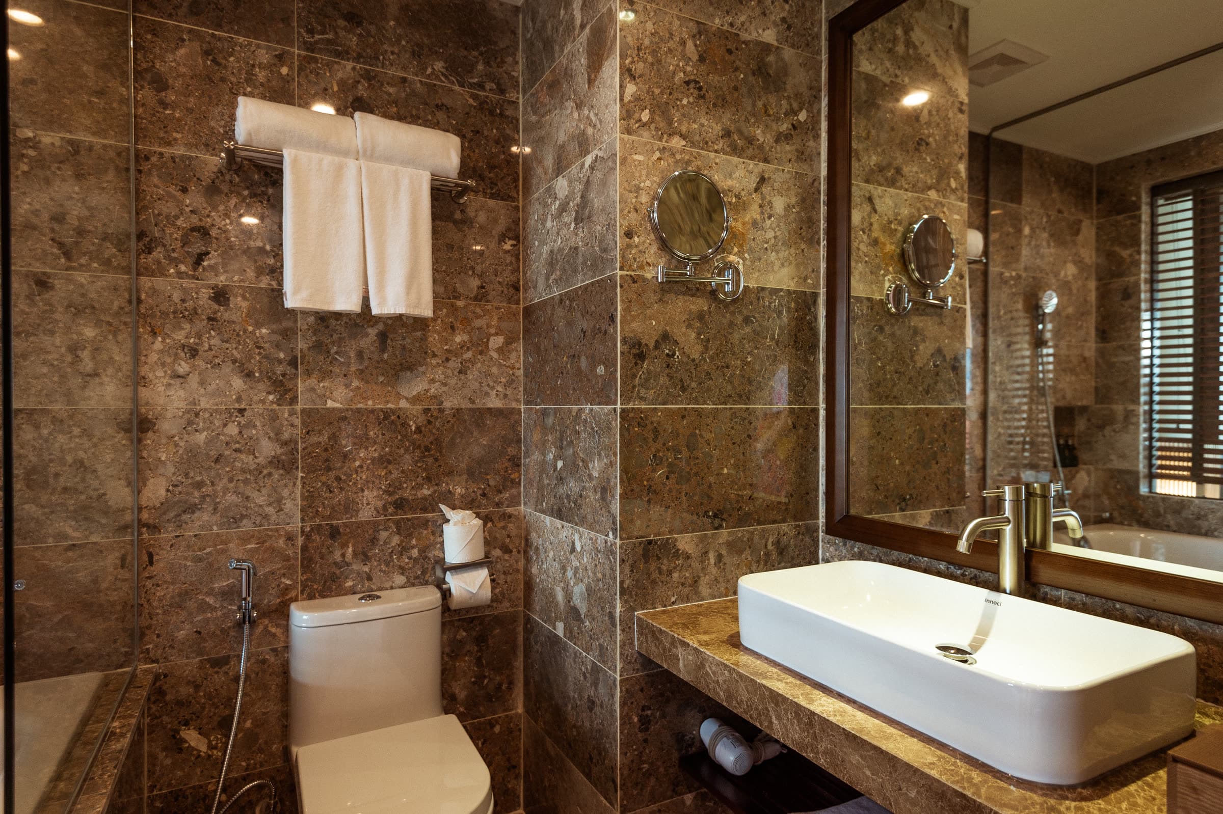 Stone bathroom of the River Suite with a bathtub and a stone-topped vanity