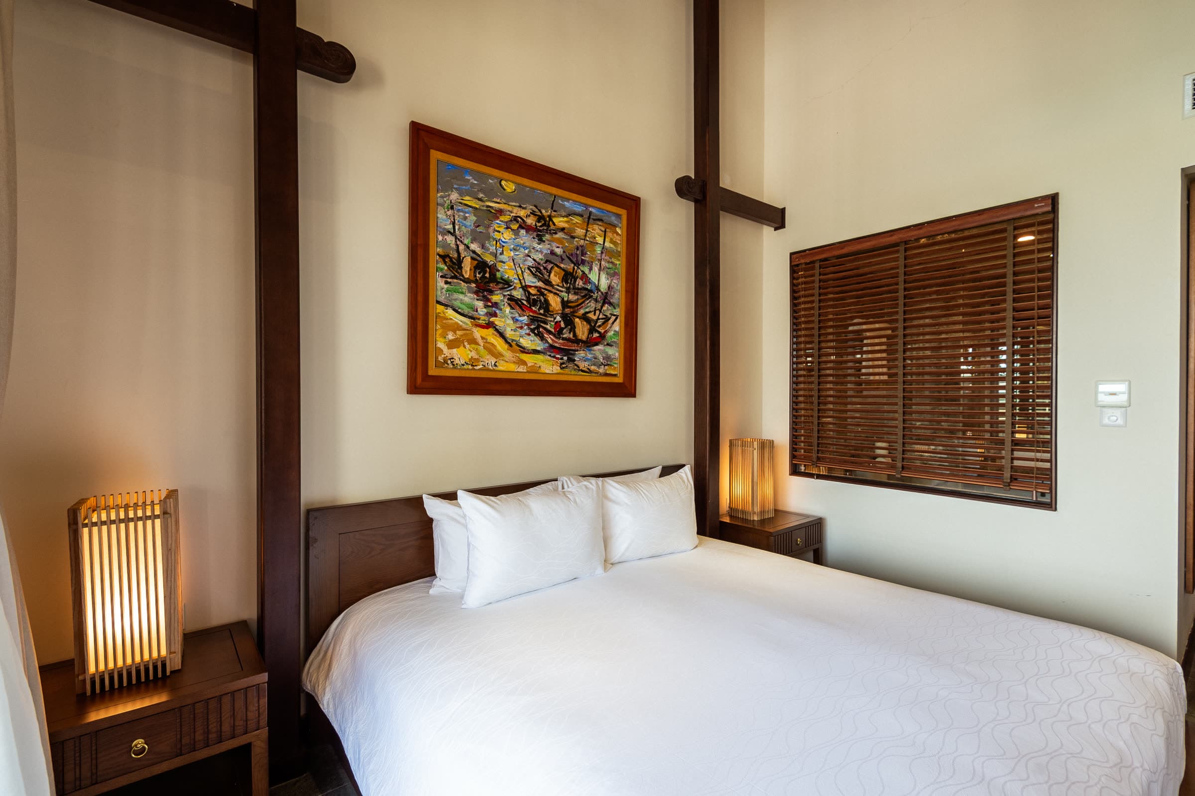 Deluxe Double bed with louvred timber shutters and bedside lanterns