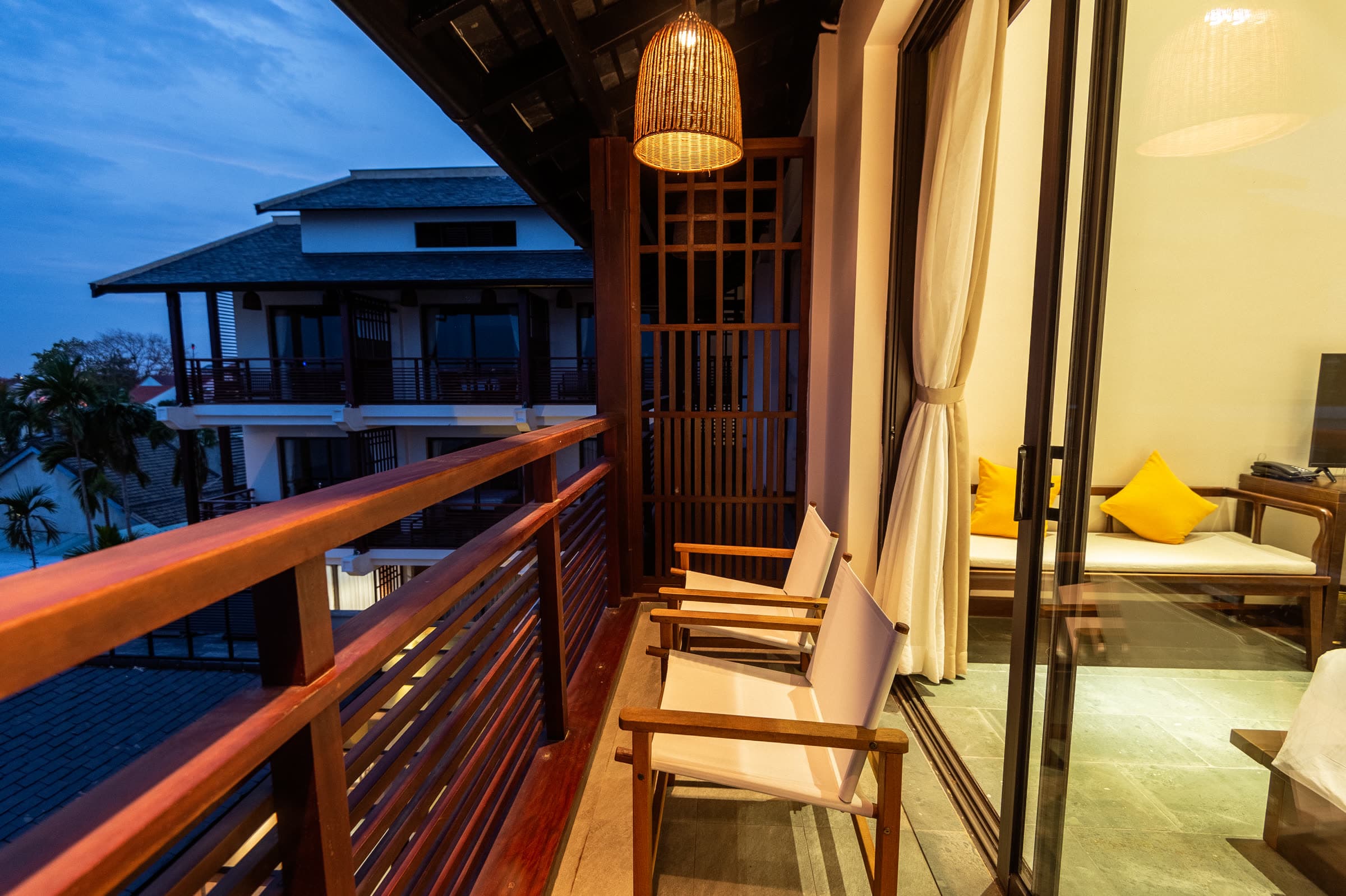 The Family Duplex balcony at dusk, chairs facing the river