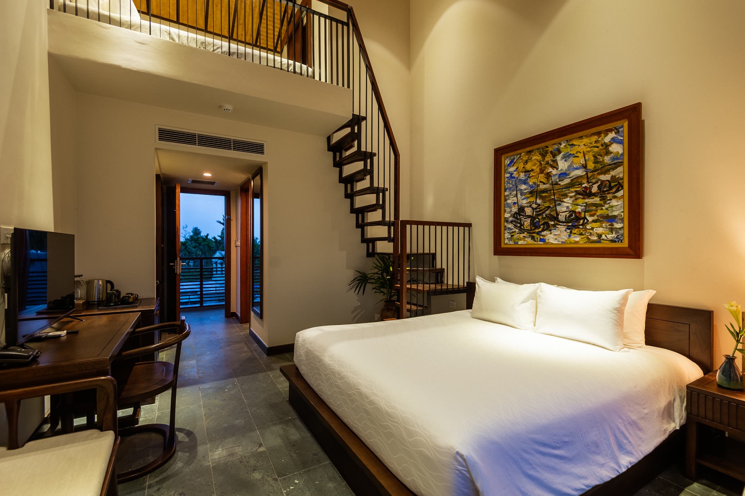 Family Duplex living level with a black spiral staircase rising to the upper bedroom
