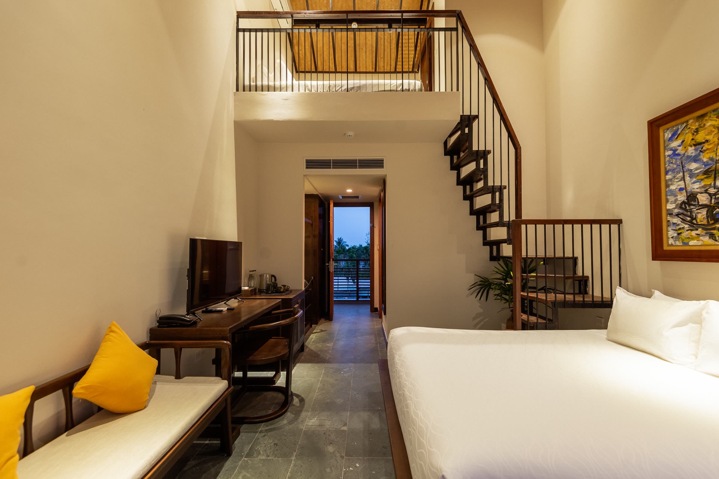Day bed and writing desk beside the spiral staircase in the Family Duplex