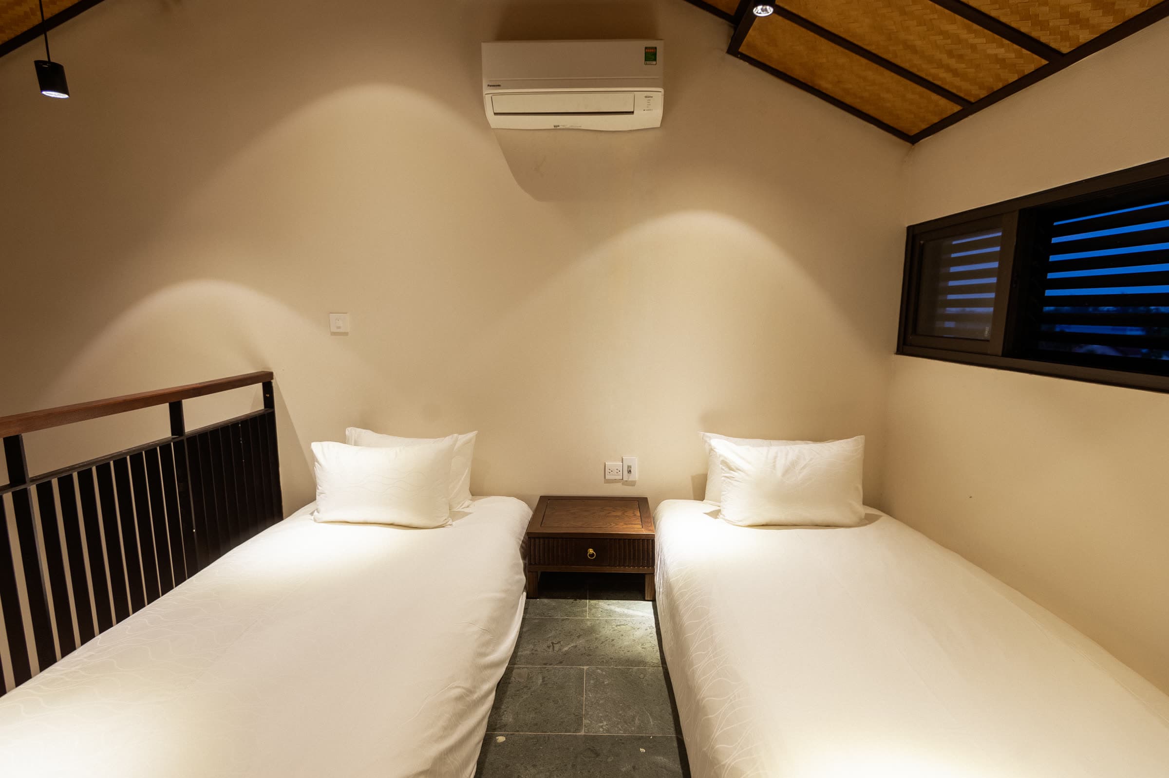 Two single beds on the mezzanine level of the Family Duplex, under the pitched roof