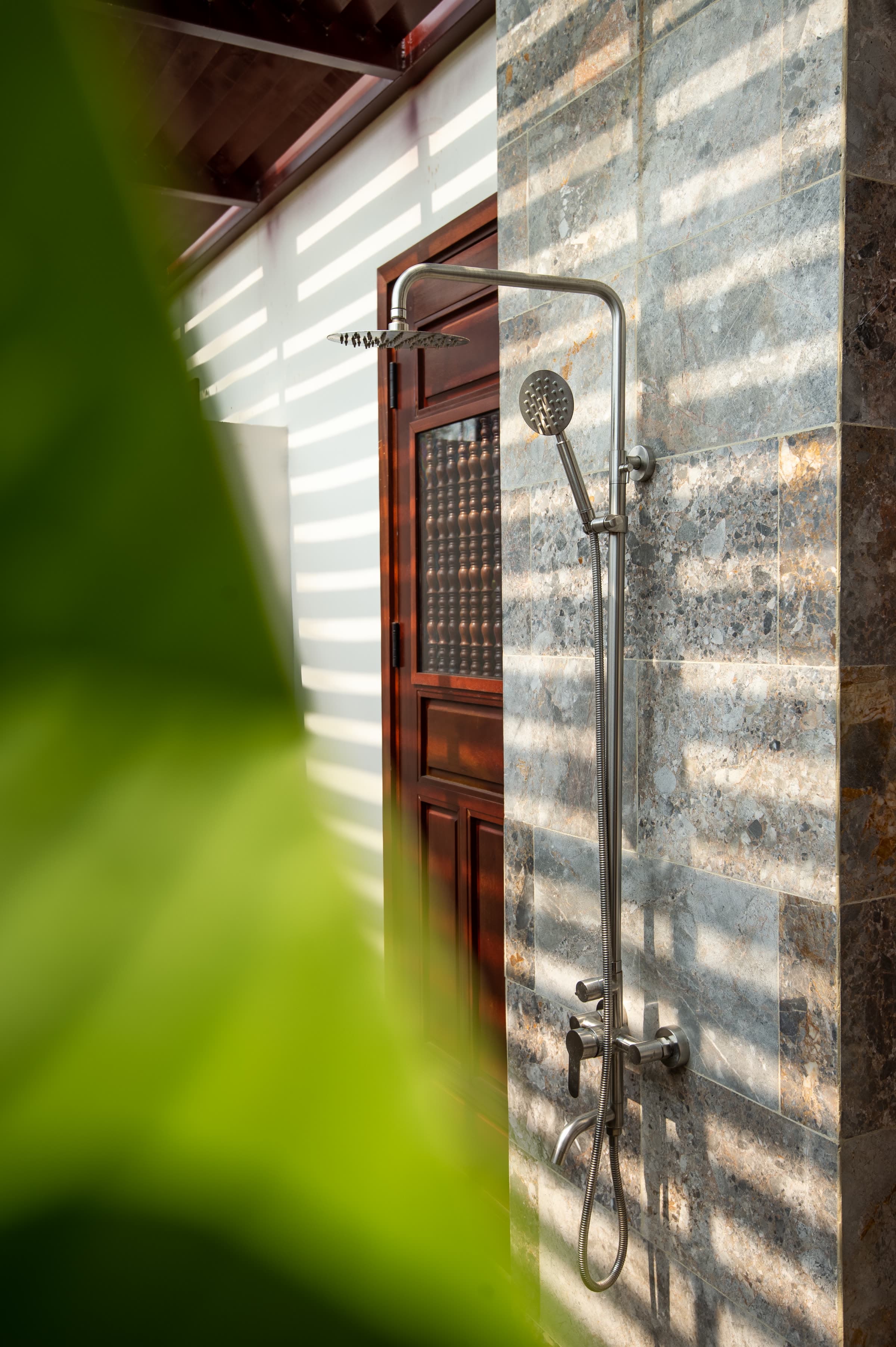 The Junior Suite's outdoor rain shower against a stone wall, open to the sky