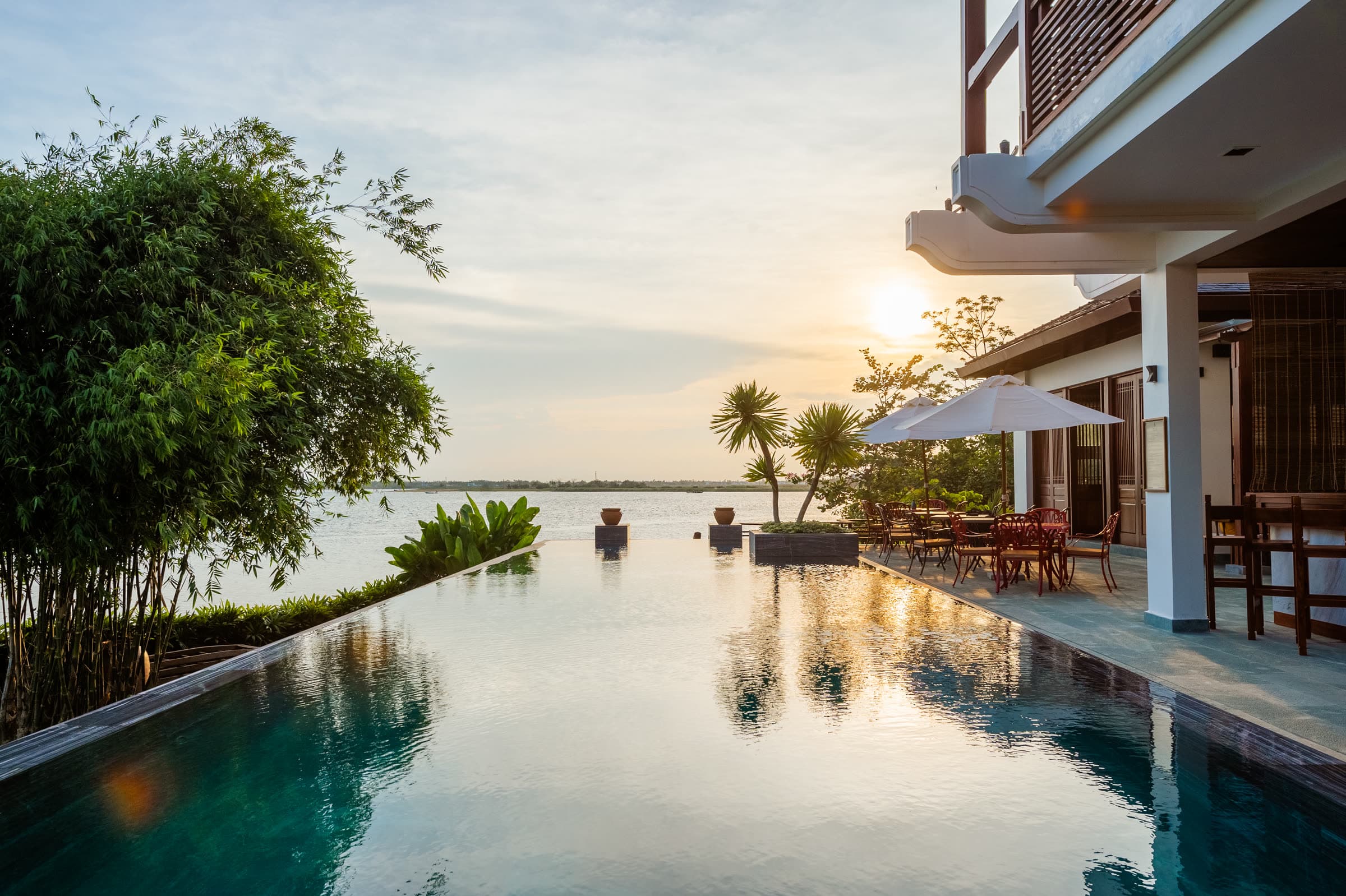 Stiller Außenpool mit Holzdeck und Hängematte zwischen Grün — die Form eines langsamen Hội-An-Tages, vom Nghê Prana, einem Hotel am Fluss in Hội An