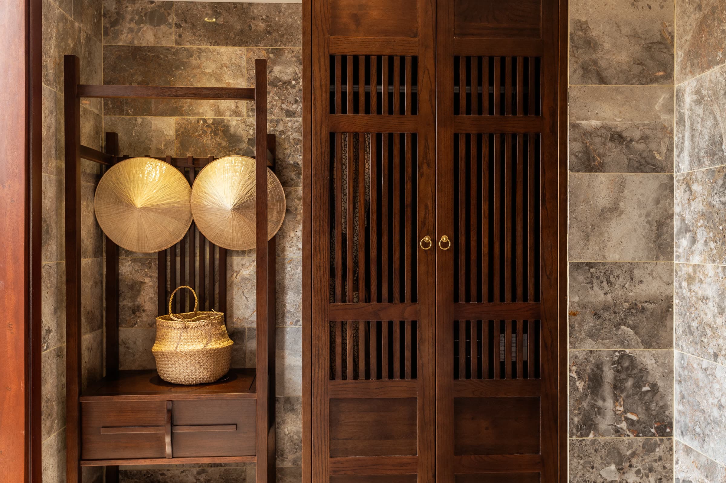 Two conical nón lá hats and a woven basket in the open wardrobe of the Junior Suite