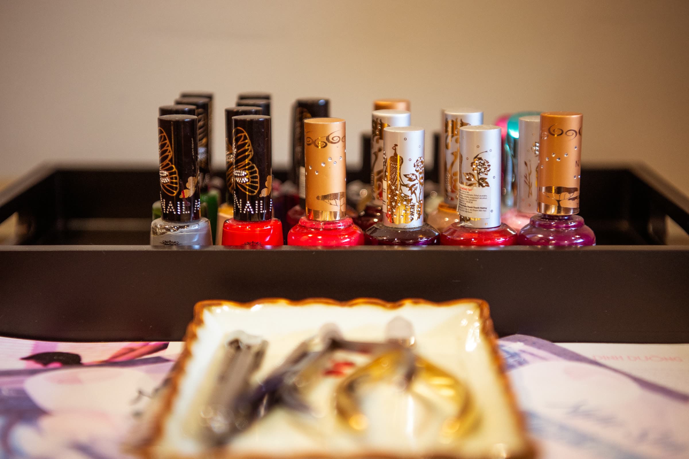 Rows of nail polish and treatment products at the Nghê Prana salon, Hội An