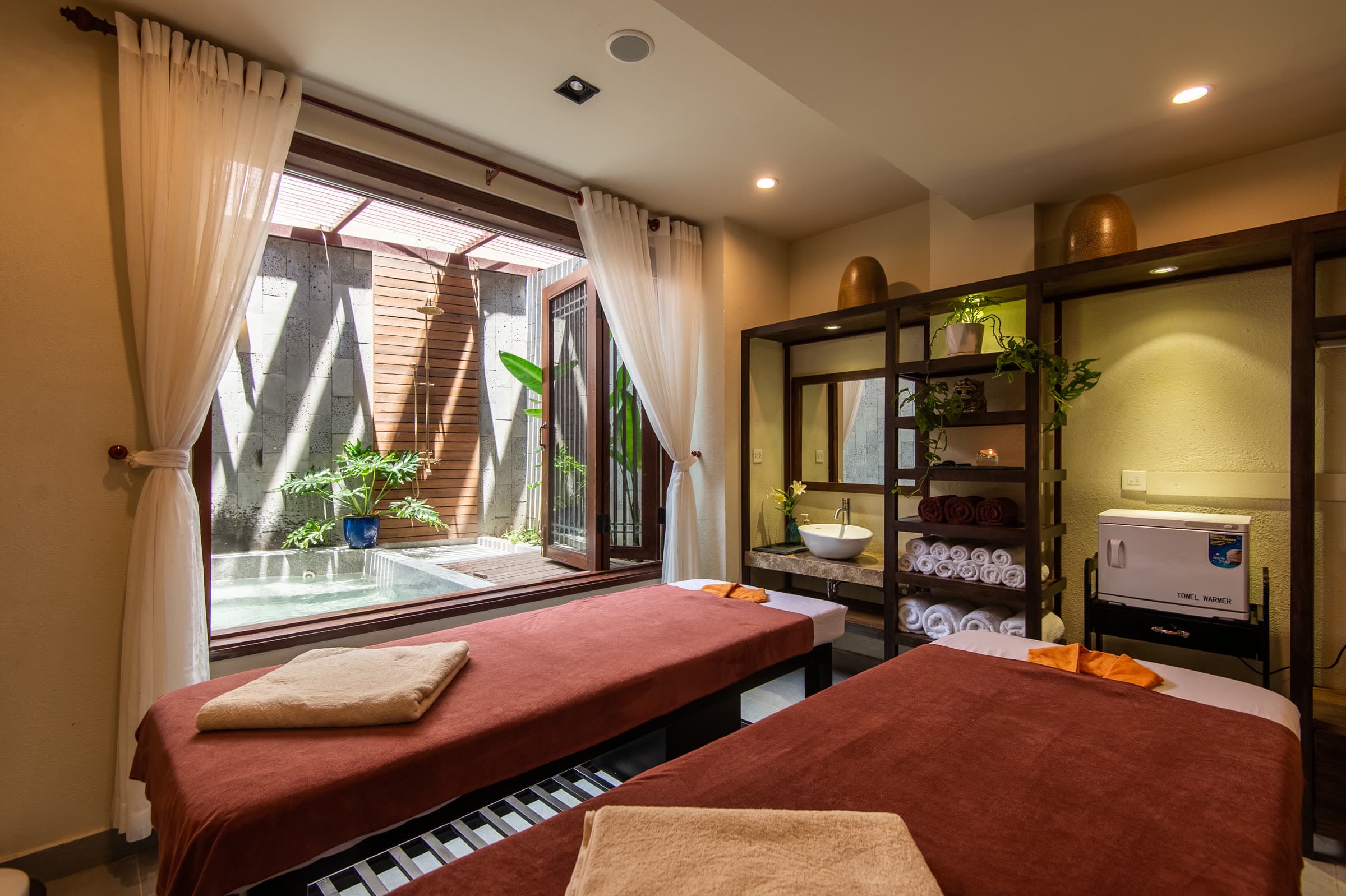 호이안 Thu Bồn 강변 스파에서 나란히 놓인 두 개의 베드와 따뜻한 촛불이 있는 커플 마사지 룸