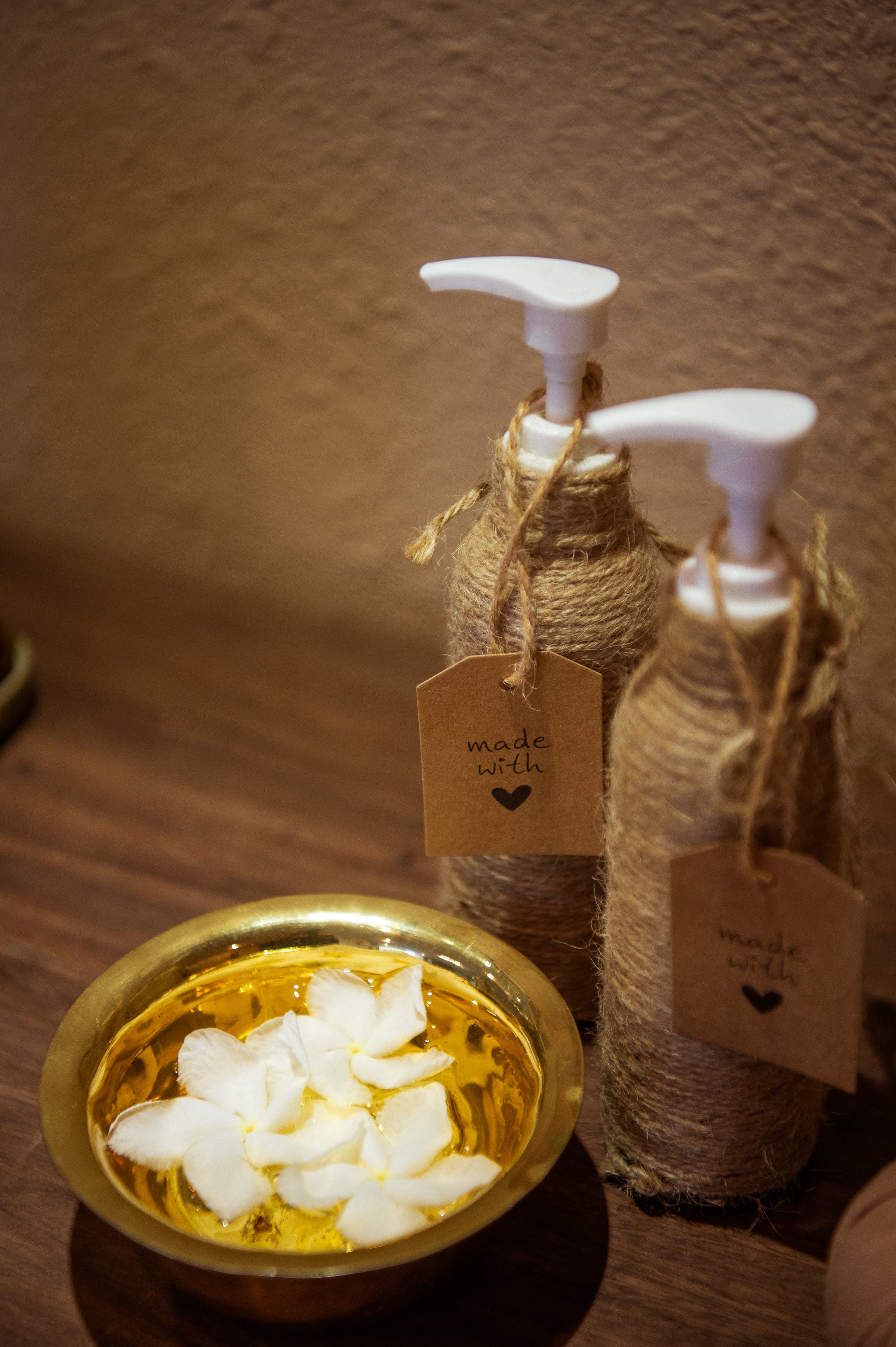 Frangipani flowers in a brass bowl beside the treatment beds at Nghê Prana spa, Hội An