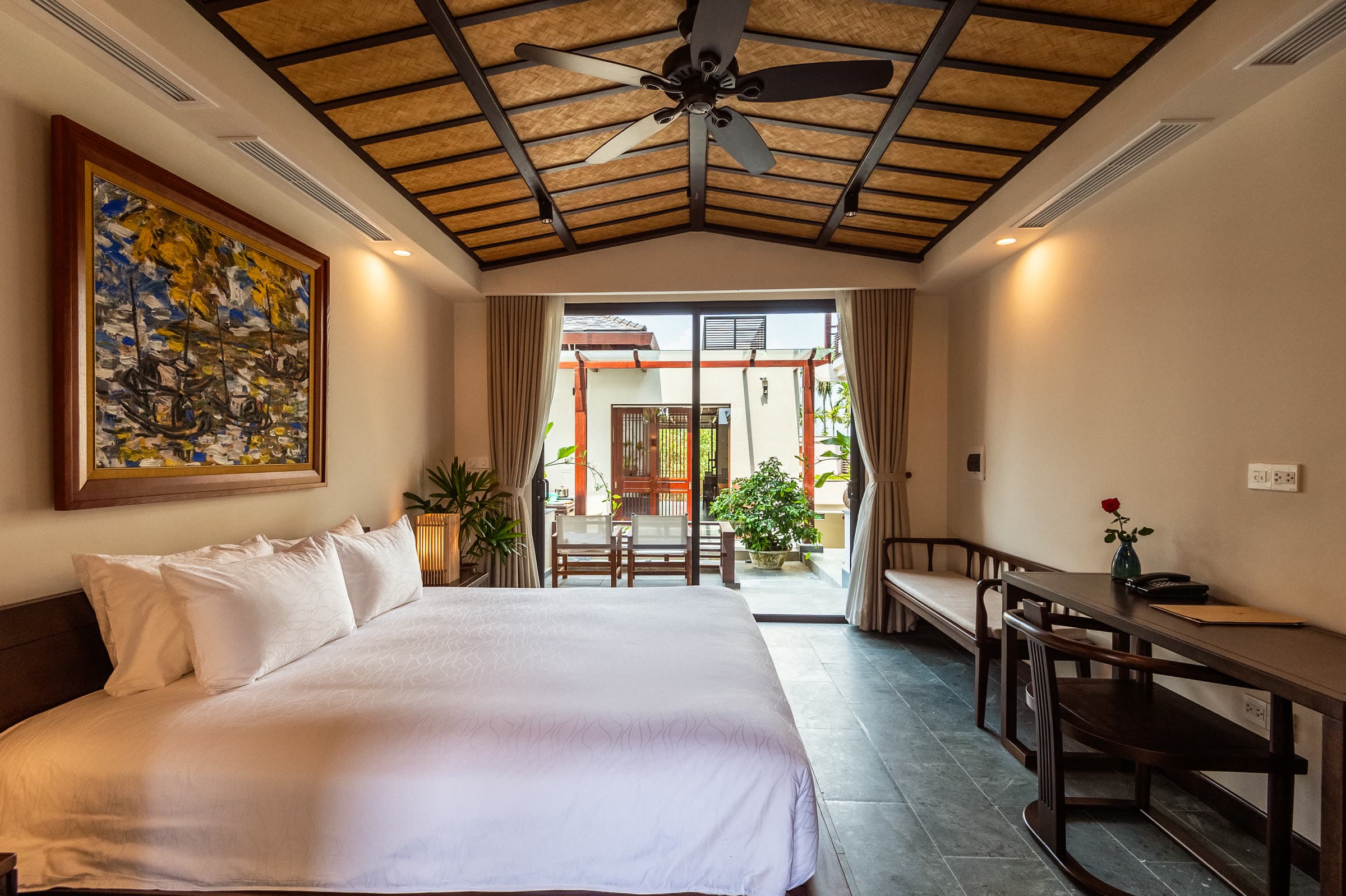 Junior Suite bedroom with the doors folded back to its private terrace