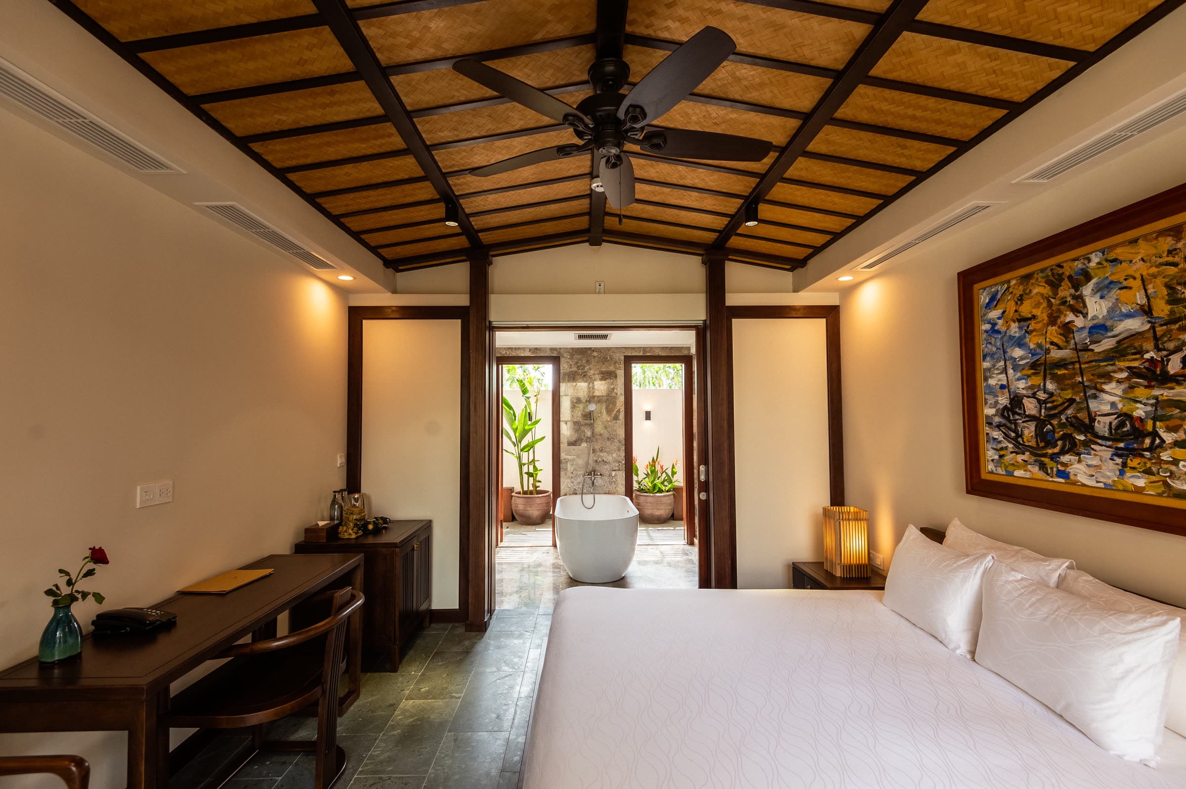 Full view of the Junior Suite: writing desk, bench and bed under the pitched timber roof