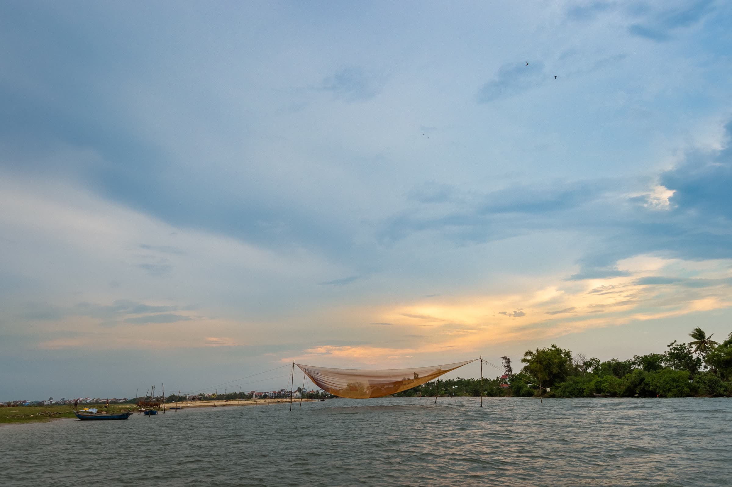 A Vietnamese square dip net on the Thu Bồn River at sunset, seen from Nghê Prana in Hội An