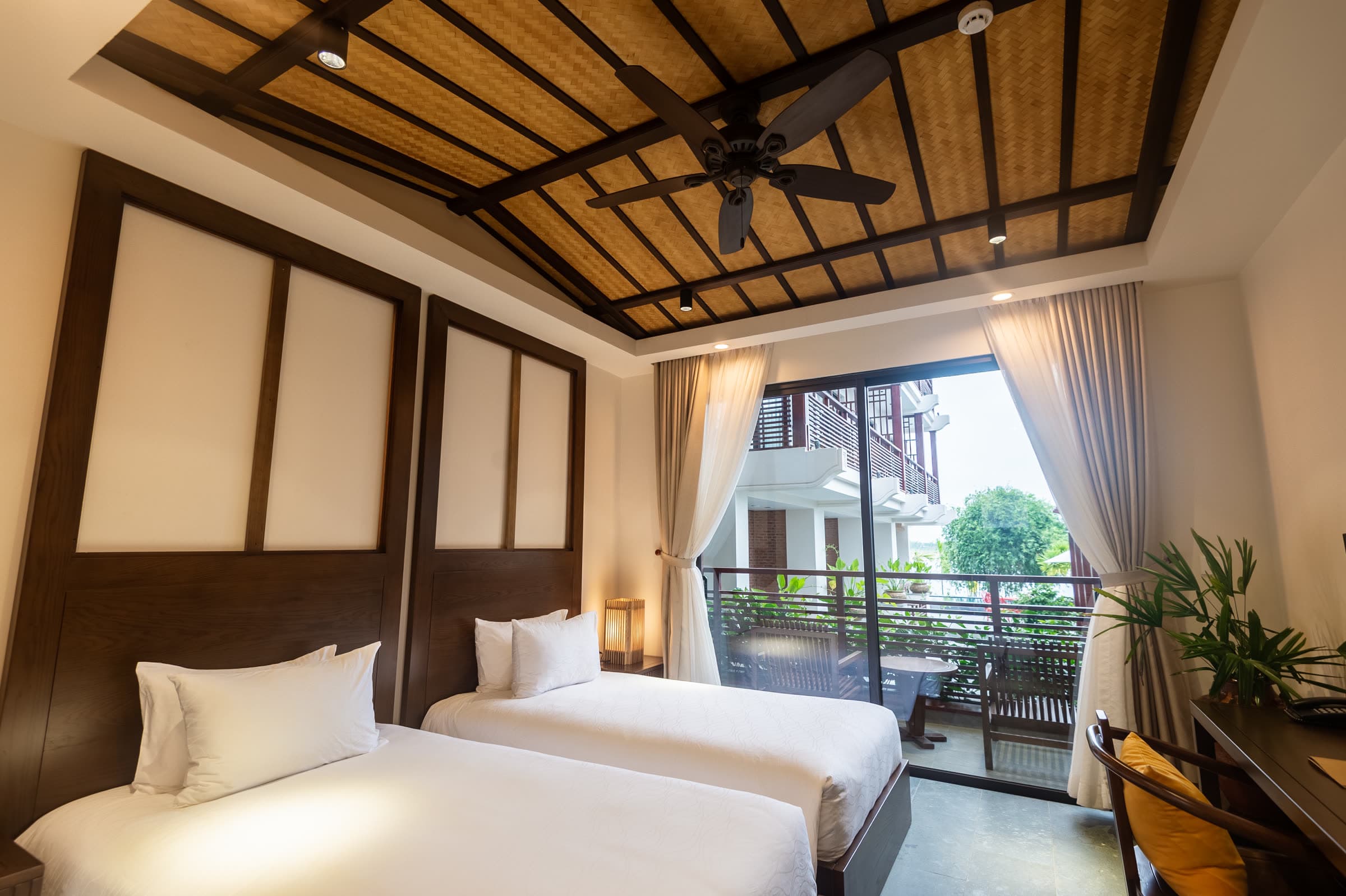 Ying and Yang twin room with its pitched timber ceiling and doors open to the balcony