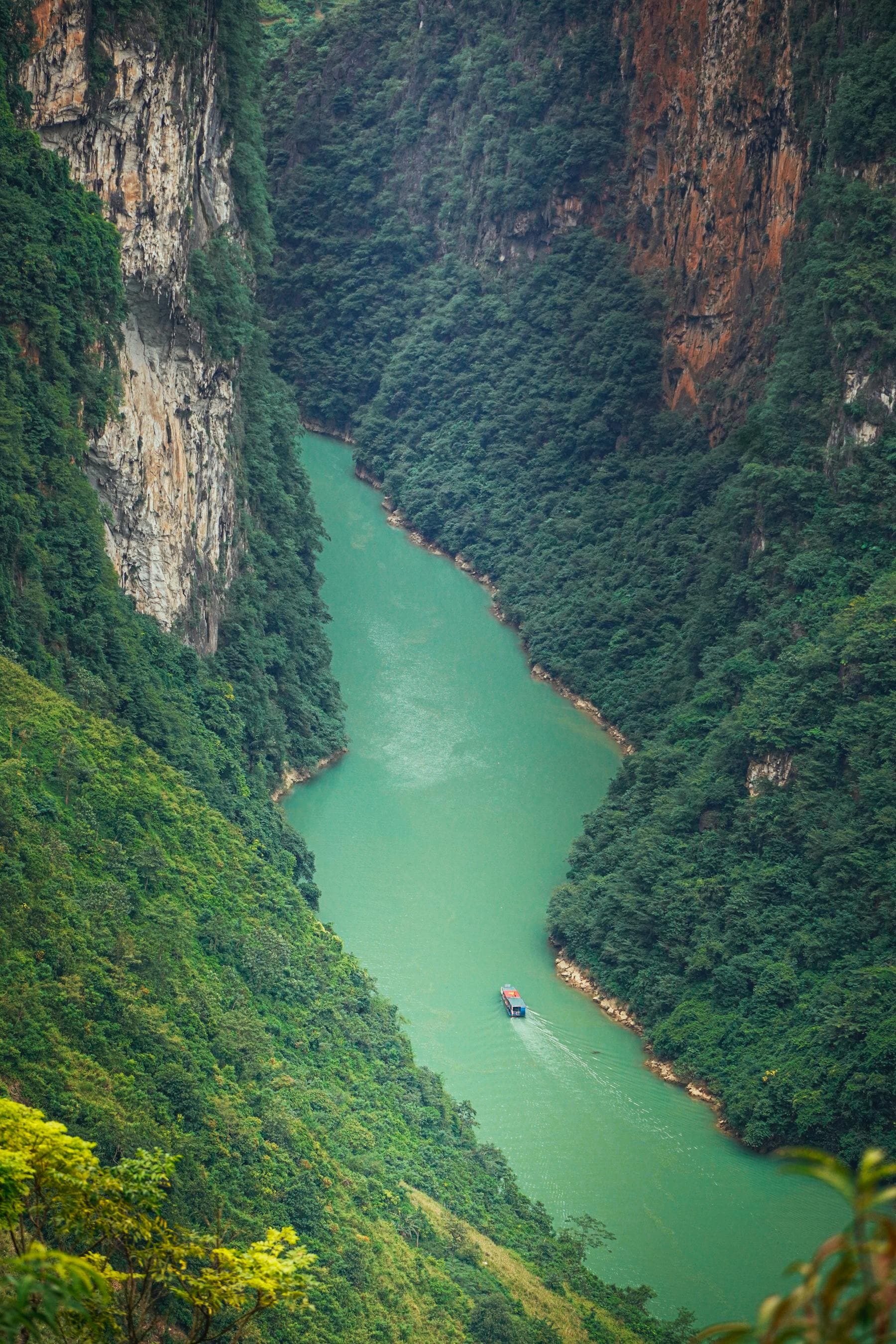 Emerald green river winding between Vietnamese karst cliffs — the riverside alternative to altitude-shifting and Skyscanner mountain travel for 2026