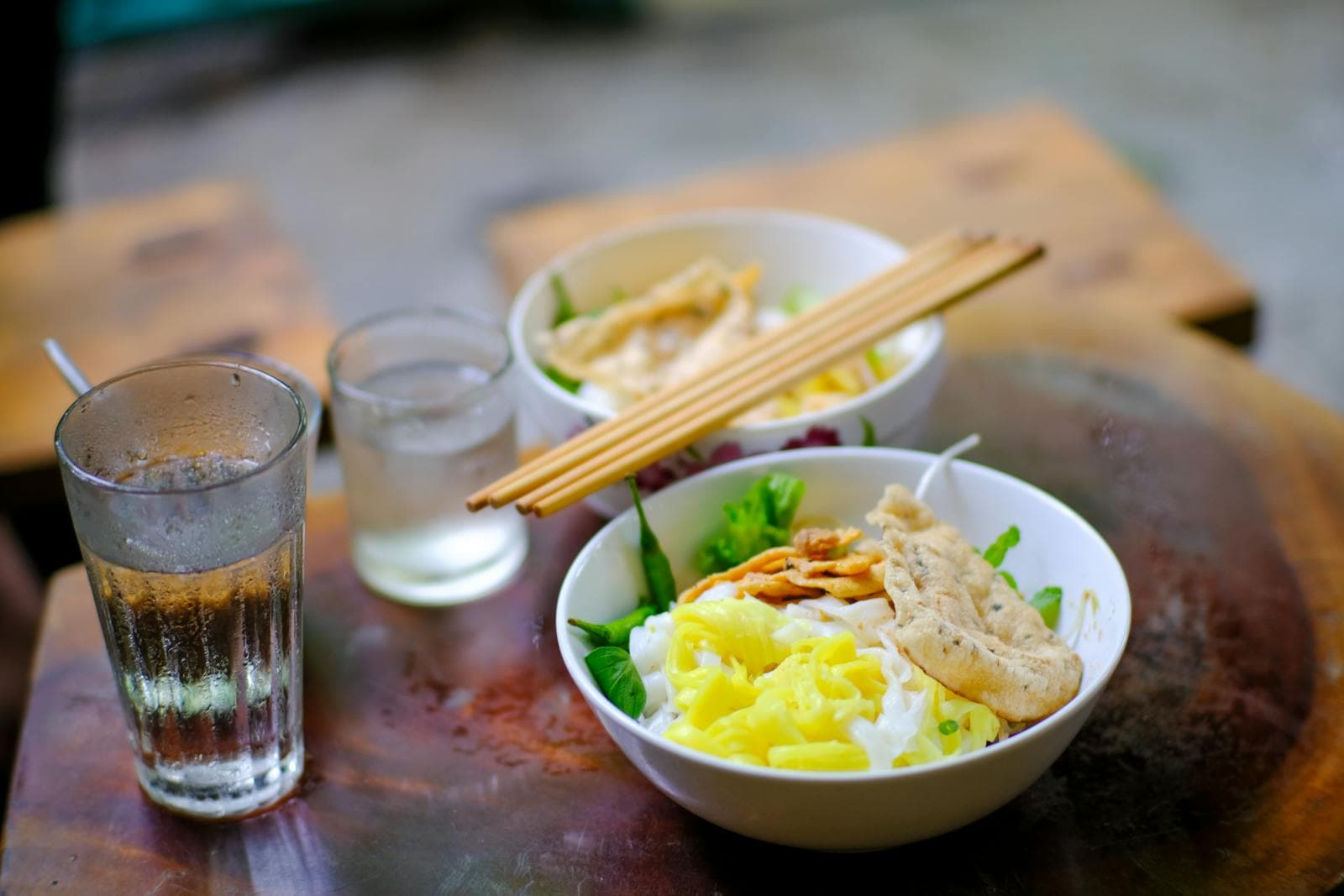 Vietnamese cao lầu noodle bowl with chewy yellow rice noodles, char siu pork, fresh herbs and crispy noodle croutons — the signature riverside dish of Hội An, central Vietnam