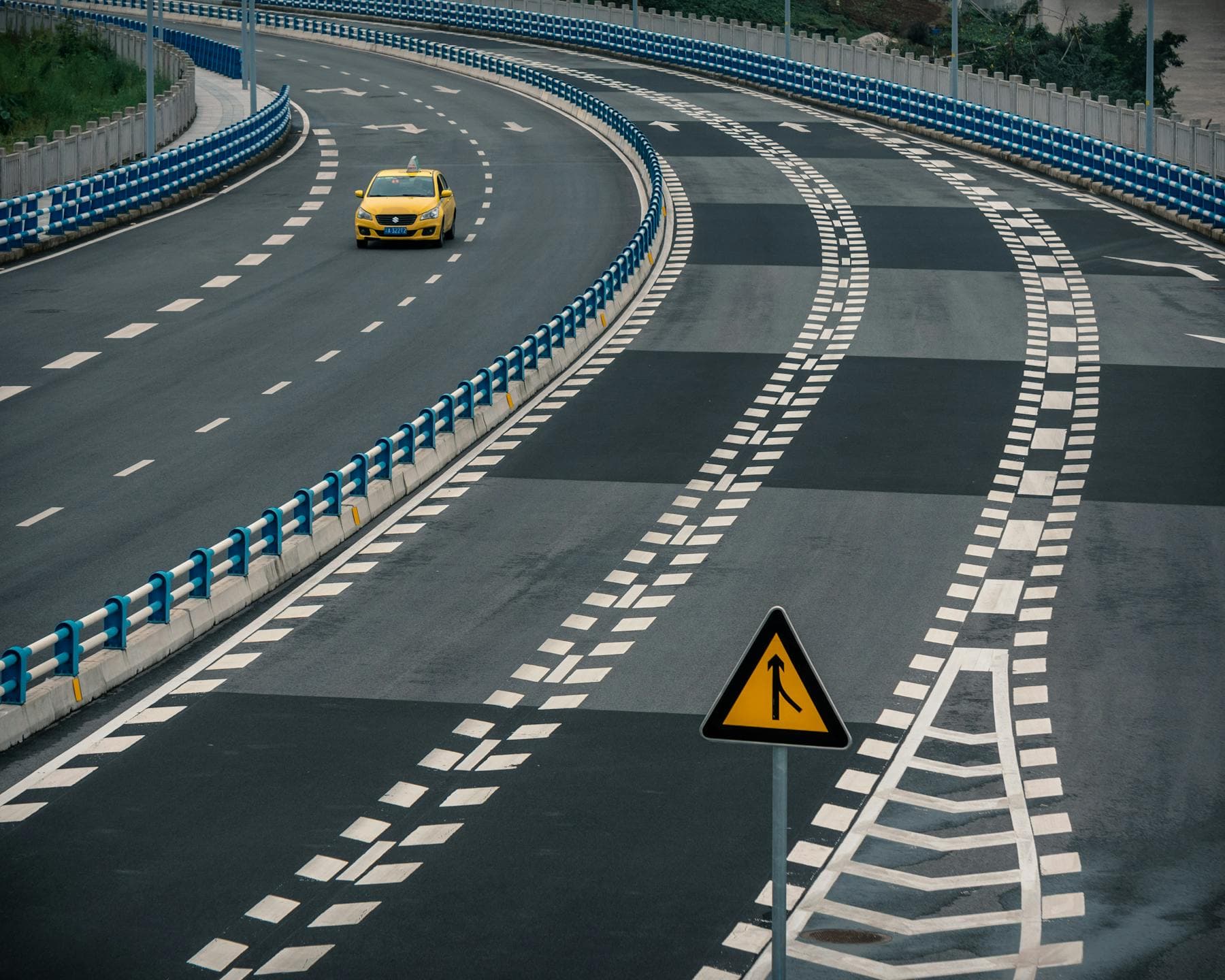 Yellow taxi on a curving Vietnamese highway — Da Nang International Airport to Hoi An transfer ride, 45 minutes south to Nghê Prana, a Hoi An riverside hotel