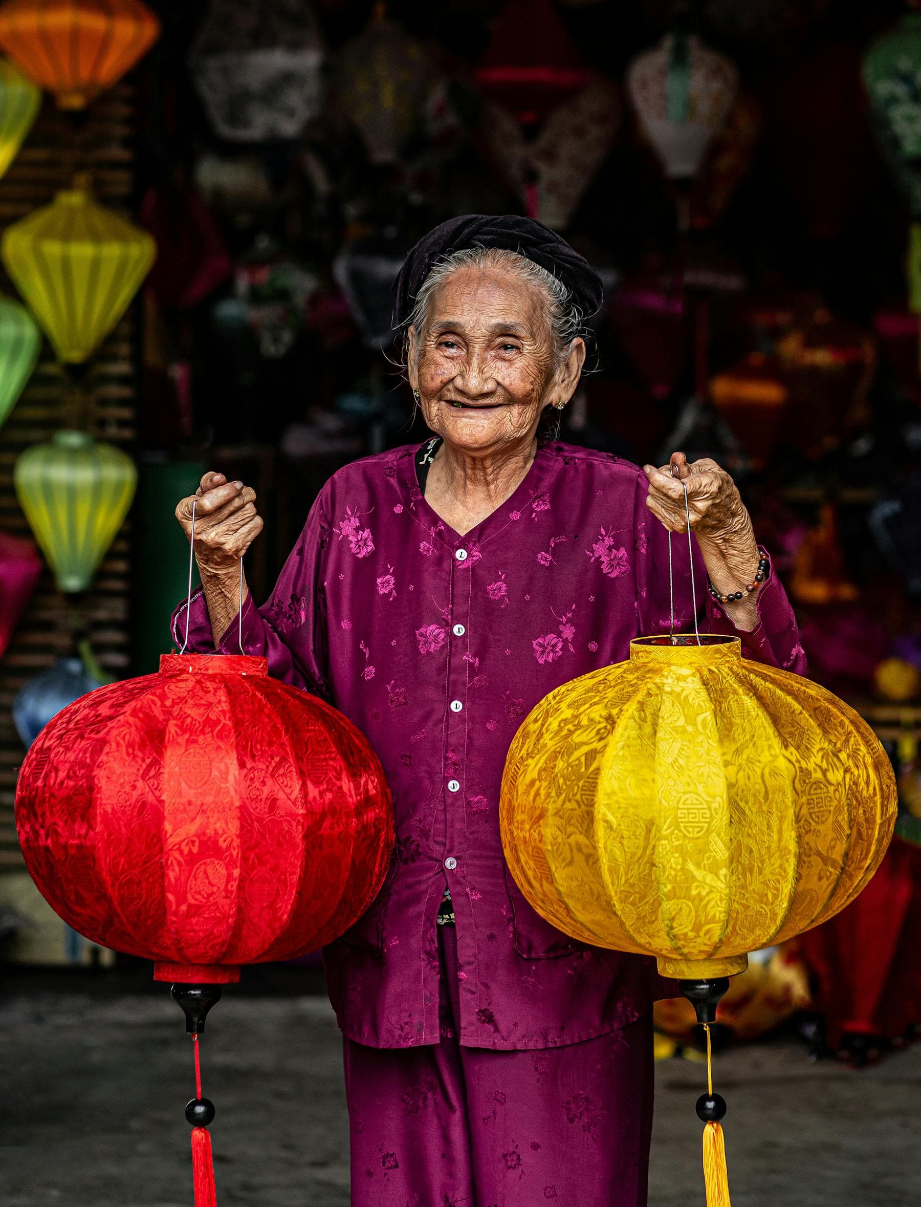 Femme vietnamienne en áo dài jaune assise parmi des fagots d'encens rouges et des têtes de lion jaunes, sous des banderoles rouges à parallèles du Tết — scène de Nouvel An lunaire